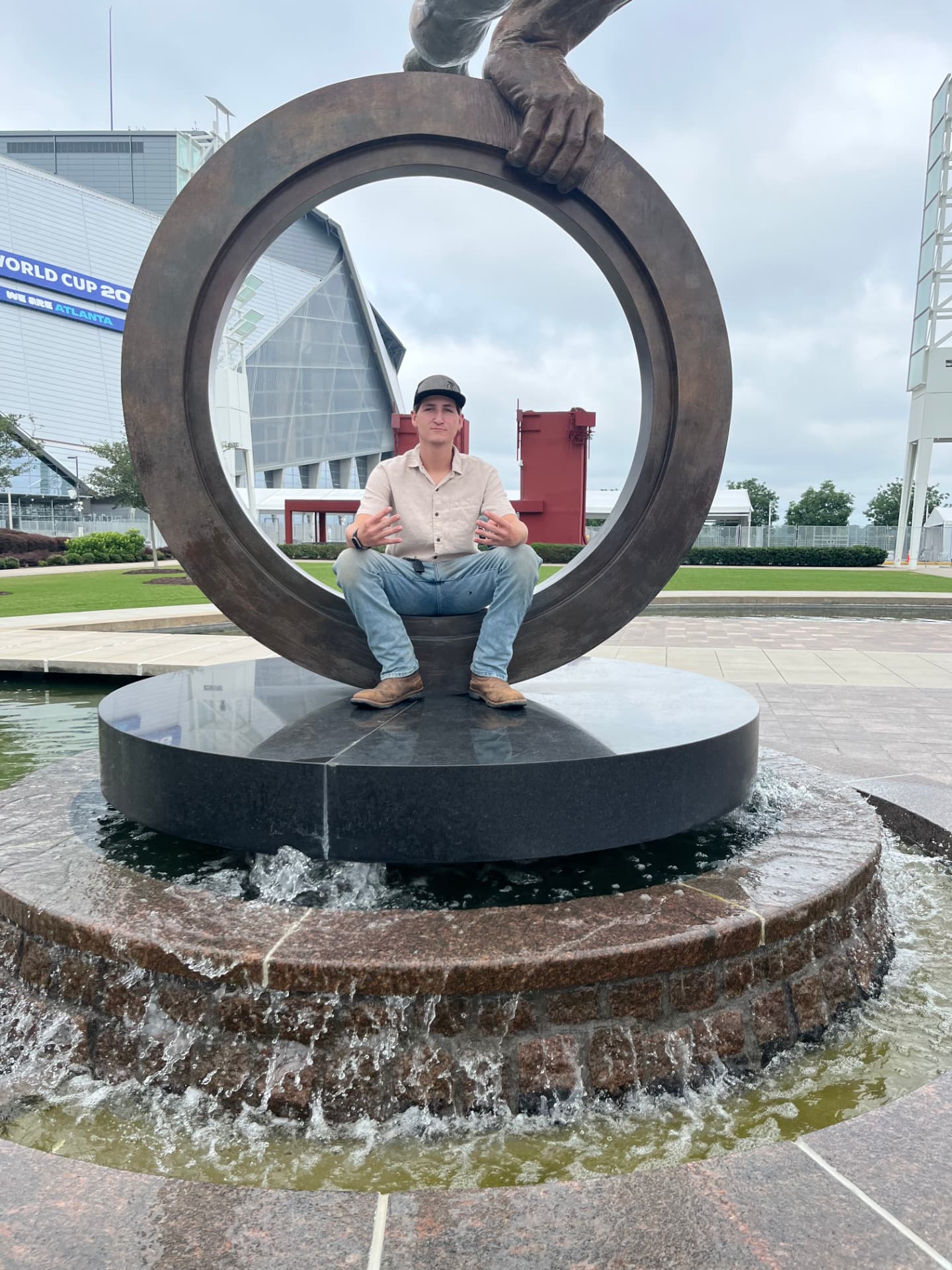 Hayden sitting inside a circular sculpture in downtown Atlanta near the stadium