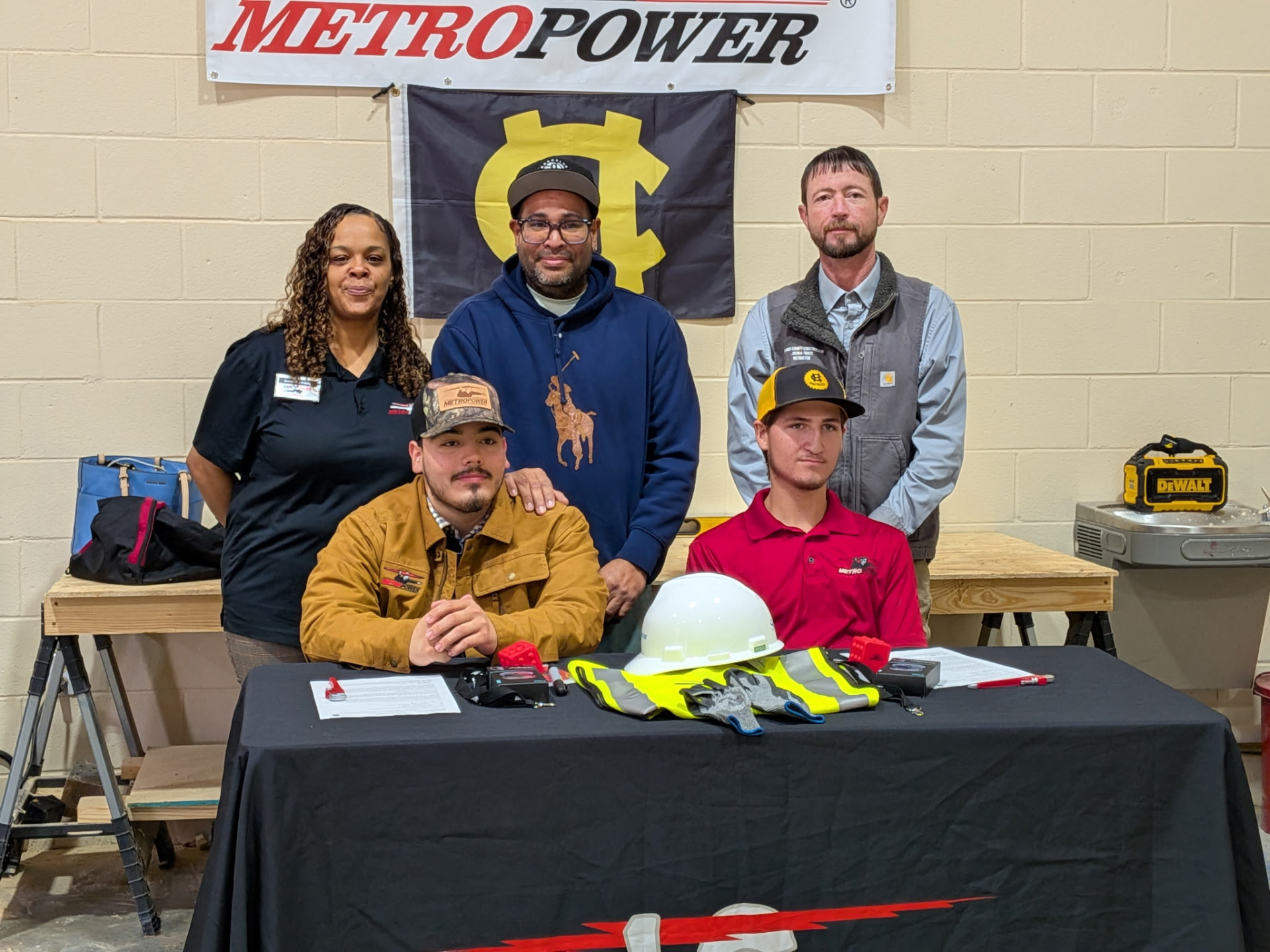 Hayden at a MetroPower signing ceremony table with instructors and company representatives