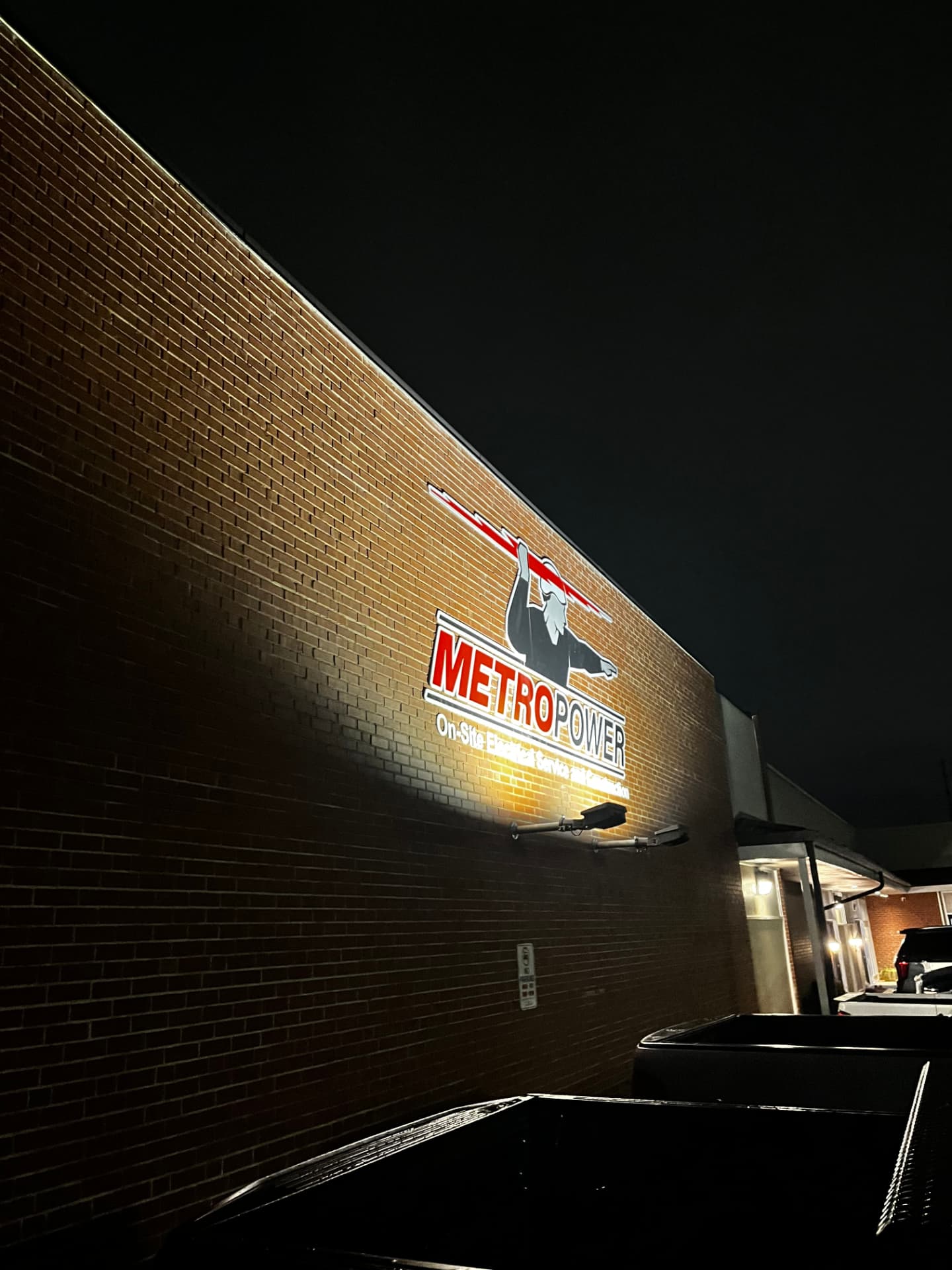 Illuminated MetroPower sign on a brick building at night