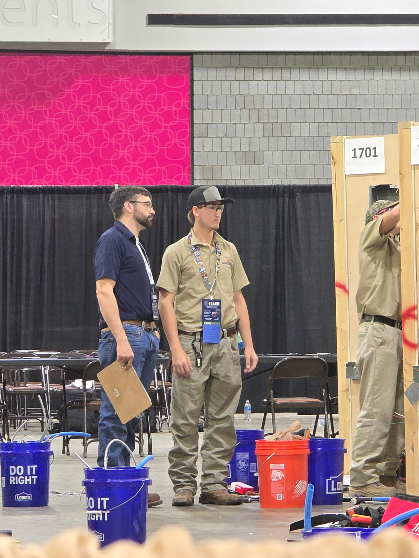 Hayden observing a competitor at wiring station 1701 on the contest floor