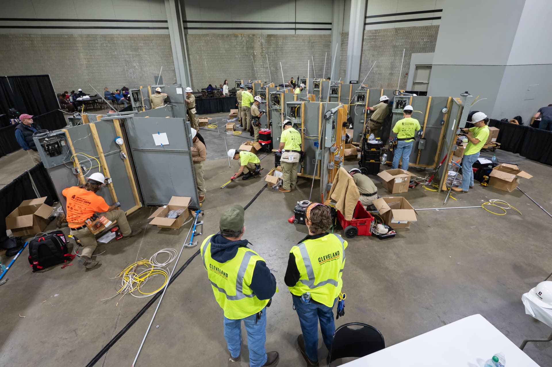 Wide view of an Electrical Construction Wiring contest floor with competitors working at panel stations