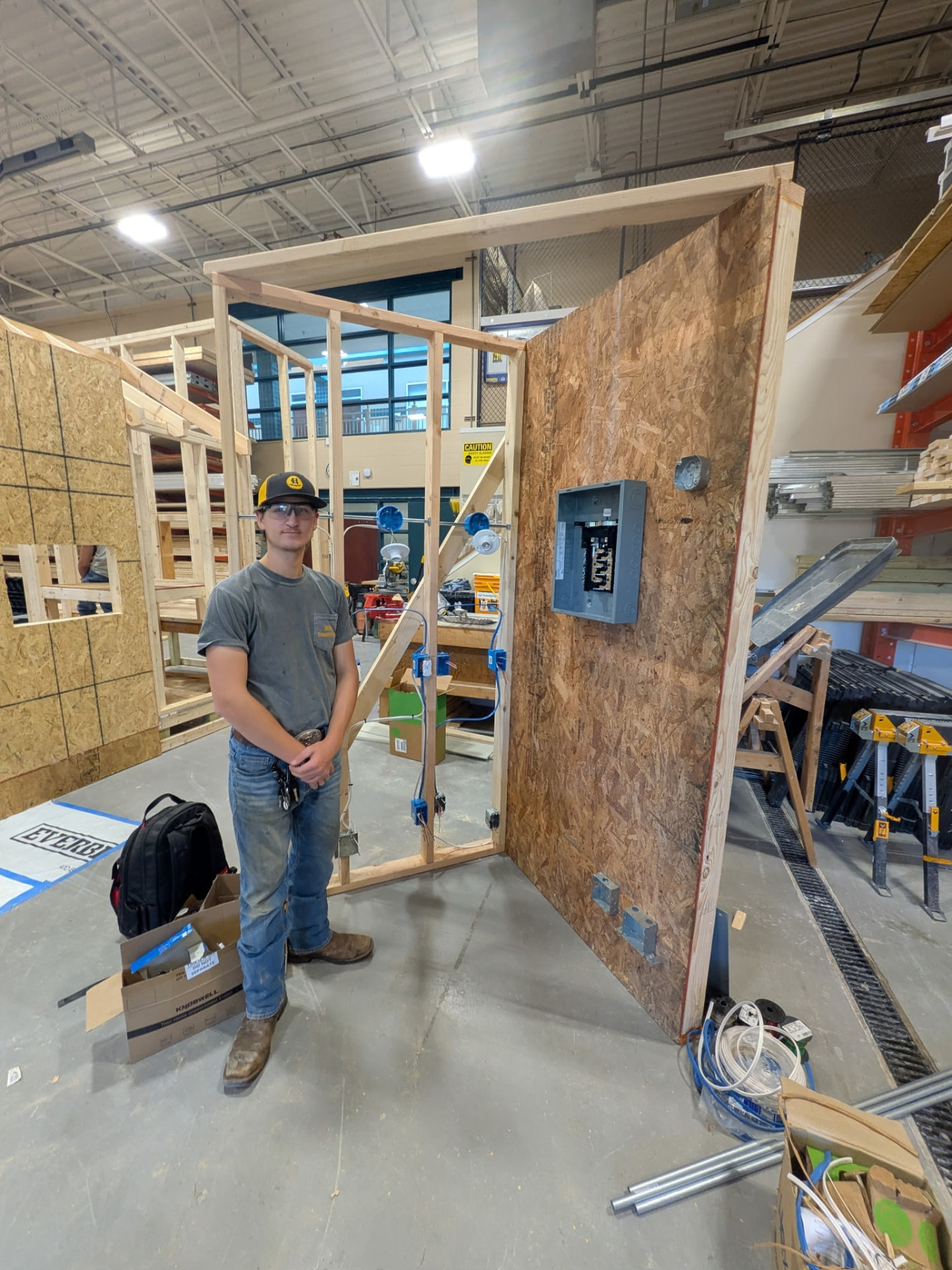 Hayden standing next to a completed electrical wiring competition frame