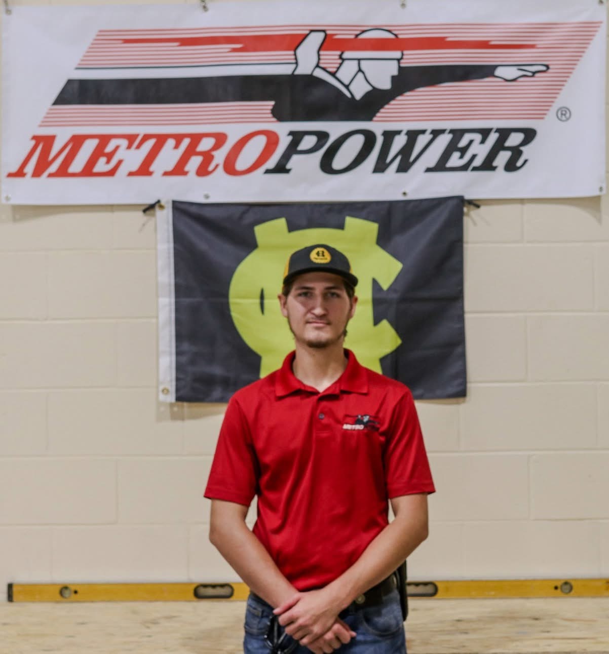 Hayden Beau Lovett in a MetroPower polo standing in front of a MetroPower banner