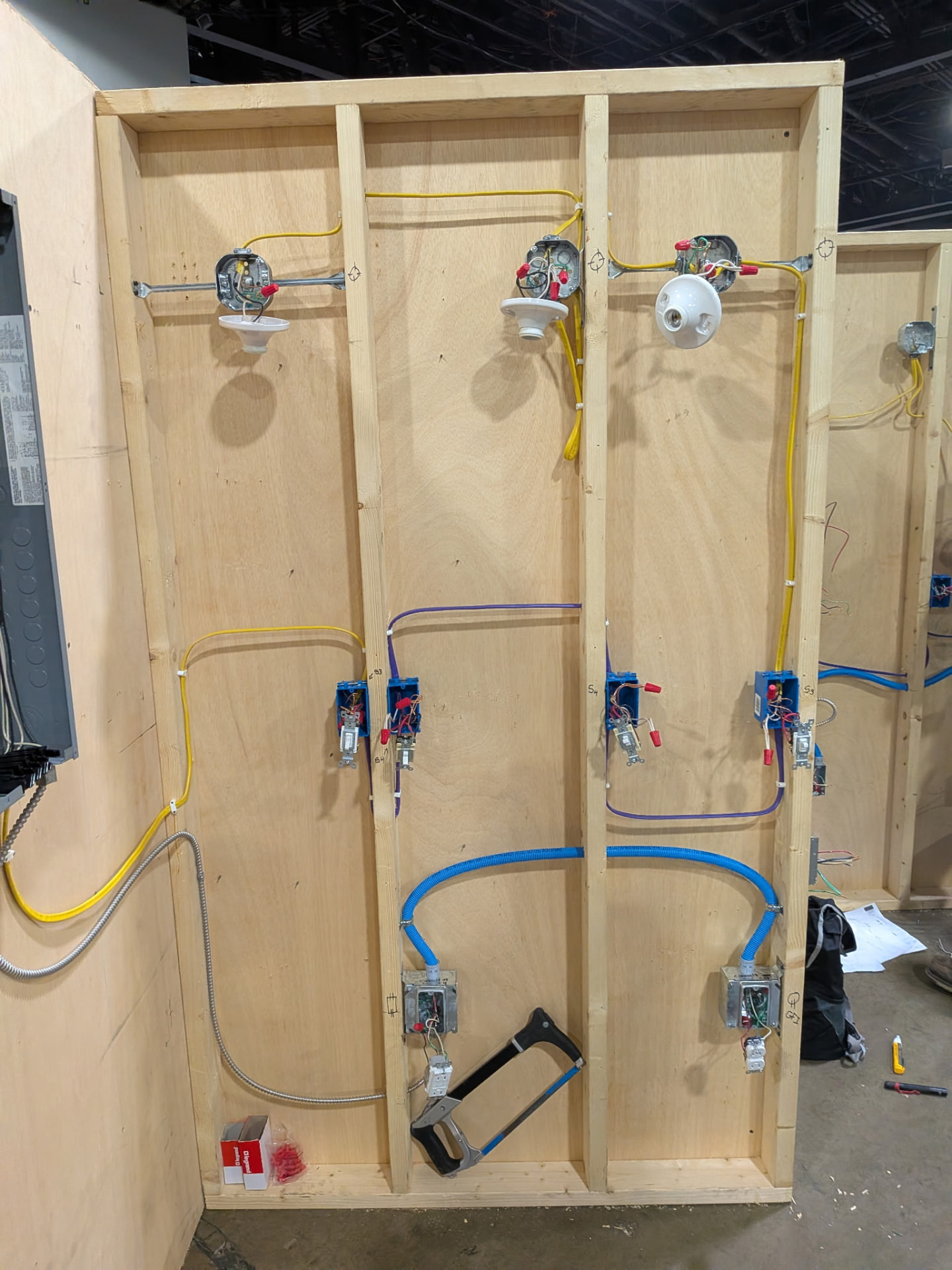 Close-up of a finished competition wiring board with device boxes, conduit, and neatly routed cable