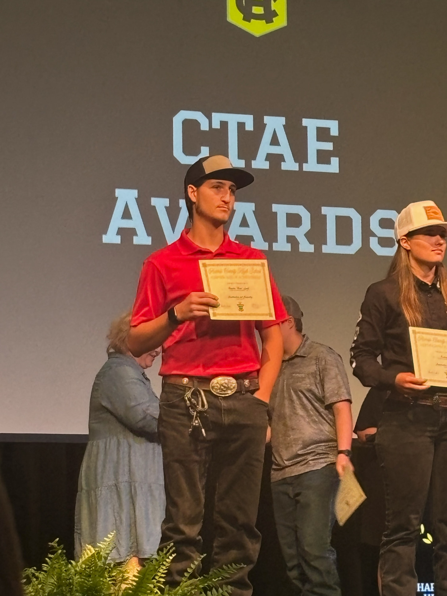 Hayden on stage holding a Harris County High School CTAE Awards certificate