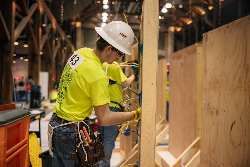 Hayden wiring an electrical panel in a hard hat
